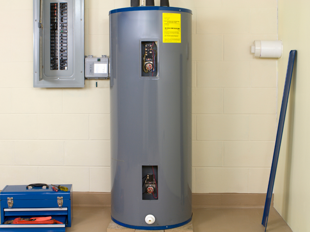 Traditional tank water heater installed beside an electrical panel