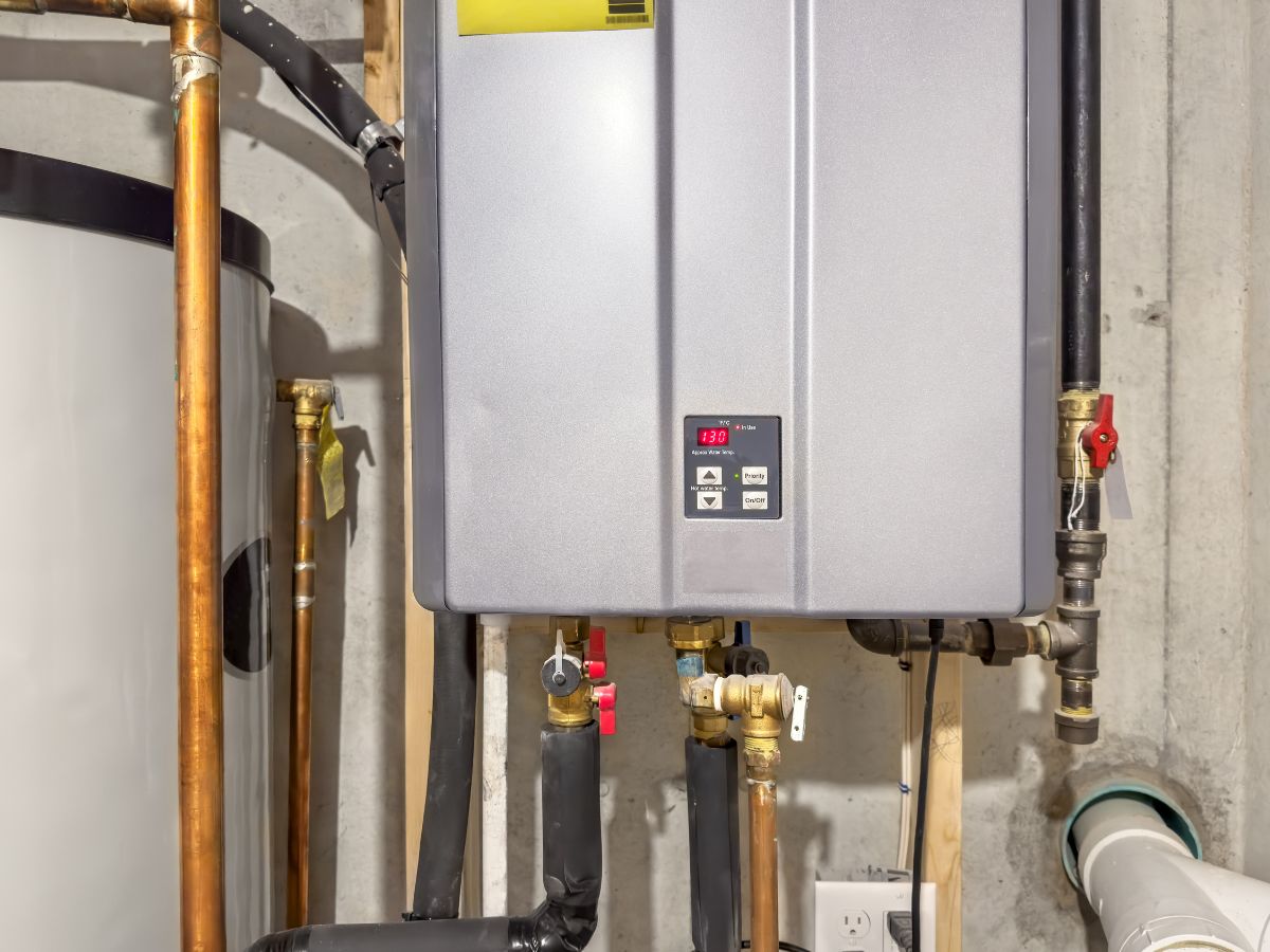 Wall-mounted tankless water heater with plumbing connections